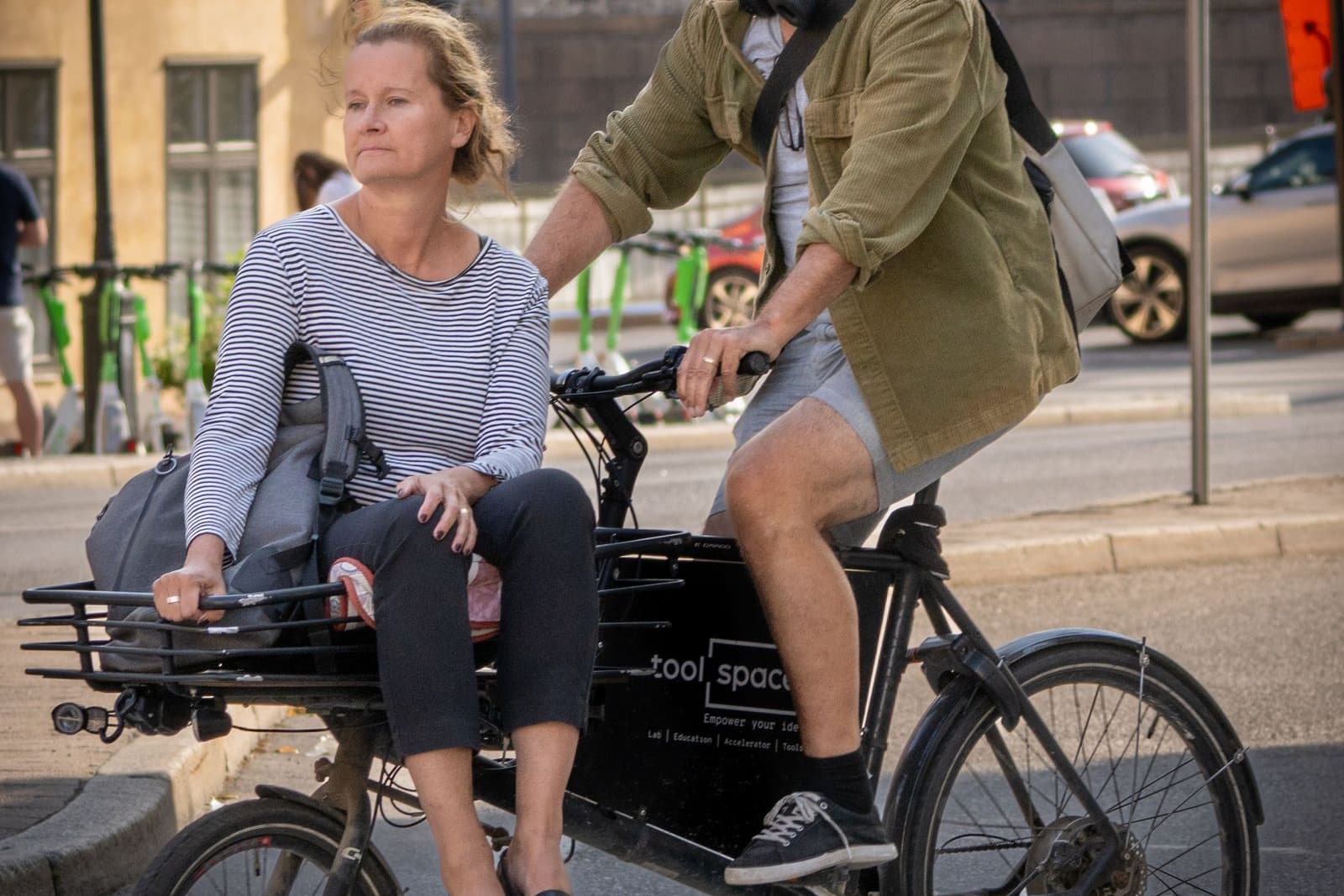 Cargo bike carrying a passenger across a city crossing