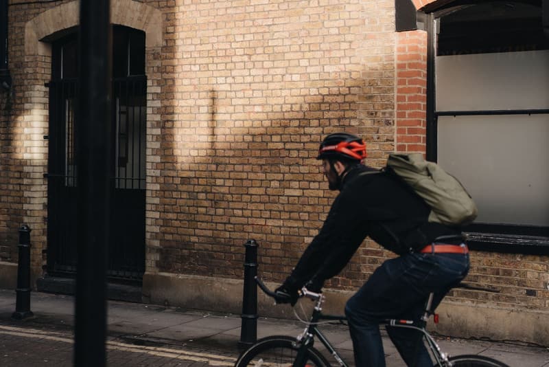 Commuter cyclist passing a numbered cycle route sign on a city street