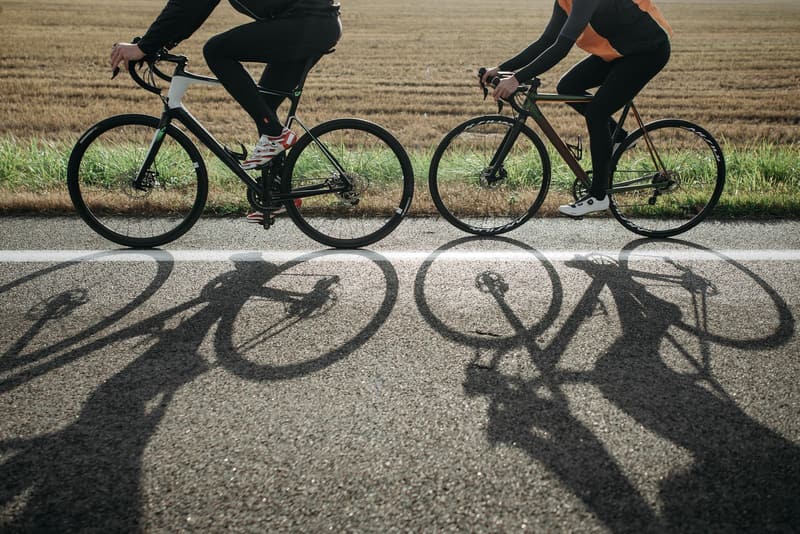 Road bikes casting long shadows on a country road in low sun